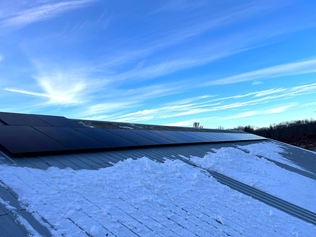 Commercial solar array on a metal roof under a blue sky