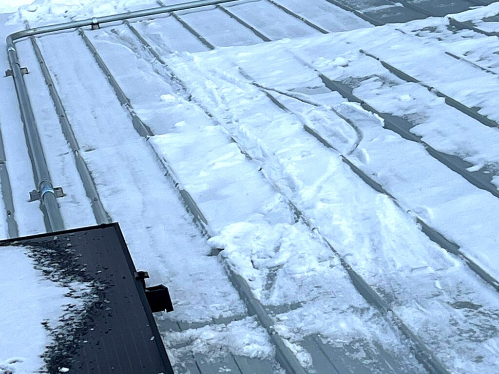 Solar array on a commercial metal roof after a snowfall