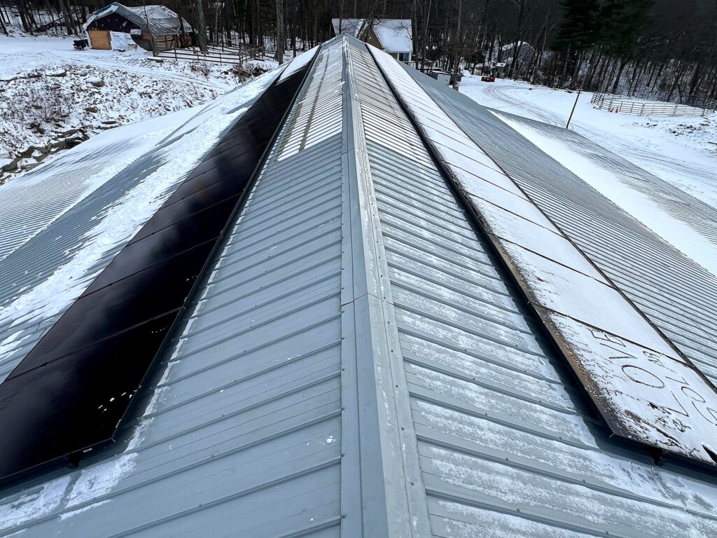 Solar arrays on both sides of a commercial metal roof in winter