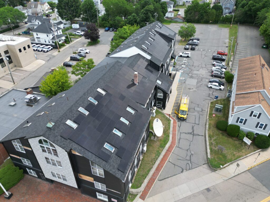 Aerial view of Fazza Commons commercial rooftop solar installation with the Alexa Energy Power Solutions service van