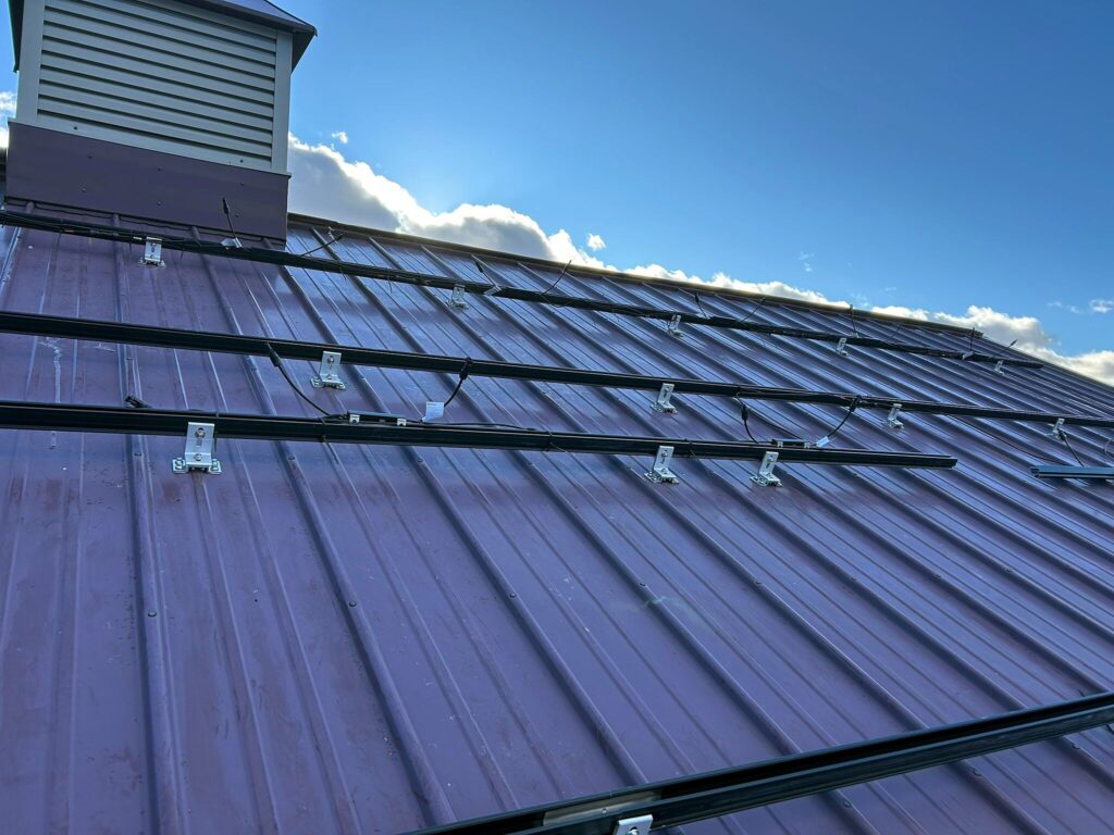 Solar racking rails and mounts installed on the metal roof next to the cupola
