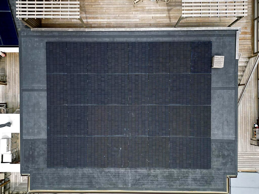 32-panel solar array on a flat residential roof in Brewster, MA