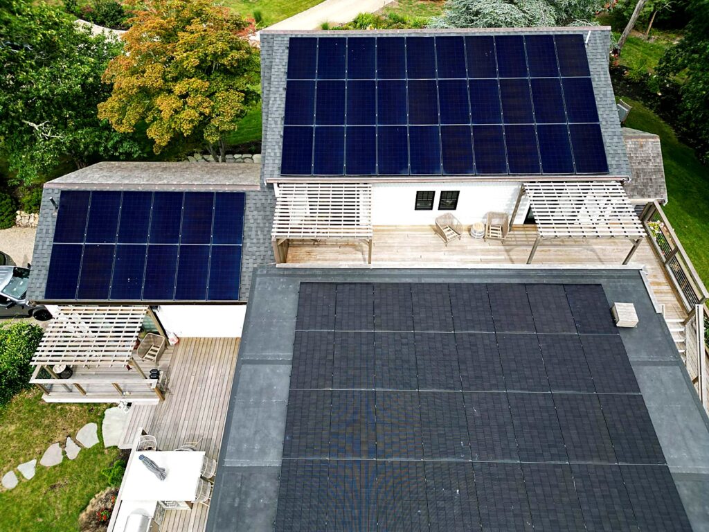 Residential solar panels on pitched and flat roofs above a deck in Brewster, MA