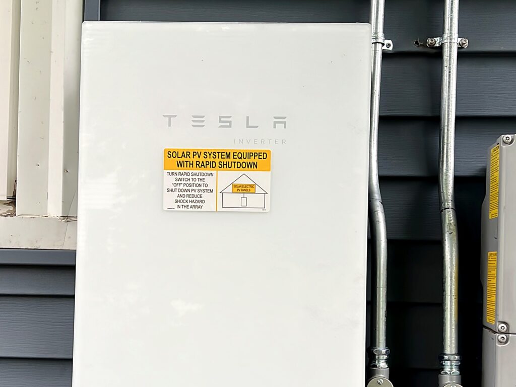 Tesla solar inverter with rapid shutdown label on a home in West Bridgewater, MA
