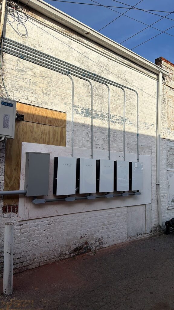 Tesla battery units and conduit on the building wall